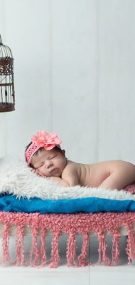 Newborn baby in a cozy, soft-lit setting, capturing the innocence and delicate features of early life.
